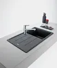 A modern kitchen sink with a chrome faucet and a dark gray basin, set on a light gray countertop. Produktbild-Vorschau