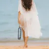 A person walking on a beach holding a water bottle. Náhľad obrázku produktu