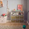 A child's room with a storage unit filled with toys, a stuffed watermelon, and a toy telephone. Anteprima dell’immagine prodotto