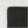 A close-up view of the corner of a black rug with a textured surface, set against a white background. Produktbild-Vorschau