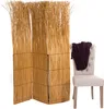 A room divider made of natural reeds stands next to a chair with a dark brown throw draped over it. Náhled obrázku produktu