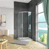 A modern bathroom with a curved shower enclosure, white brick wall, and large window with green curtains. Produktbild-Vorschau