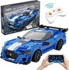 A blue toy sports car with racing stripes, a remote control, and a smartphone displaying a control interface. Produktbild-Vorschau