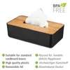 A black tissue box with a wooden lid, containing white tissues, is shown against a white background. Text describing features is present below the product. Náhled obrázku produktu