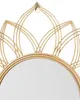 A close-up view of the top portion of a gold-colored wall mirror with a decorative, petal-like frame. Náhled obrázku produktu