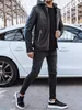 A man wearing a black leather jacket and black jeans stands next to a white car. Voir les images du produit