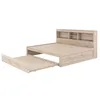 A light wood-tone bed frame with a pull-out trundle bed and a bookshelf headboard, shown against a white background. Produktbild-Vorschau
