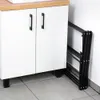 A white cabinet with black handles and a folded black drying rack next to it. Anteprima dell’immagine prodotto
