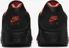 The back view of two black Nike Air Max 180 sneakers with orange accents. Náhľad obrázku produktu