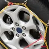 A close-up of a car tire with snow chains attached. Produktbild-Vorschau