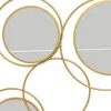 A close-up view of a gold metal wall mirror with multiple circular frames and reflective surfaces. Produktbild-Vorschau