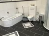 A bathroom with a bathtub, toilet, and shower. Produktbild-Vorschau