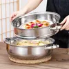 A person is holding a steaming pot with food inside, showing it off. Produktbild-Vorschau