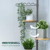 A plant stand with multiple shelves and plants on it, with arrows indicating adjustability. Produktbild-Vorschau