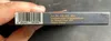A hand holding a product box with a barcode and text. Produktbild-Vorschau