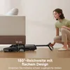 A woman is using a vacuum cleaner under a sofa, demonstrating its low-profile design. Voir les images du produit