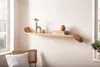 A wooden shelf mounted on a wall, decorated with vases and books. A chair with a cushion is visible in the foreground. Voir les images du produit
