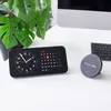 A desk setup with a digital clock and calendar, a keyboard, and a magnetic phone mount. Anteprima dell’immagine prodotto