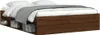 A bed frame with storage compartments underneath, filled with books and shoes. Produktbild-Vorschau