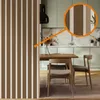 A dining area with a table and chairs, set against a kitchen background with cabinets and a marble backsplash. A decorative partition with vertical stripes is in the foreground. Anteprima dell’immagine prodotto