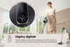 A woman is holding a handheld vacuum cleaner in a modern living room, with a close-up of the vacuum's digital display shown. Produktbild-Vorschau