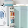 A narrow rolling storage cart filled with cleaning supplies is placed next to a washing machine and a light blue cabinet. Náhľad obrázku produktu