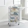 A bathroom with a sink and a rolling storage cart filled with towels and toiletries. Voir les images du produit
