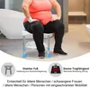 A person is sitting on a shower stool in a bathroom. Produktbild-Vorschau