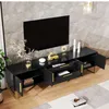 A black TV stand with gold accents is shown in a living room setting, with a TV mounted on the wall behind it. Produktbild-Vorschau