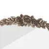 A close-up of a decorative metal frame with rose and leaf motifs. Podgląd zdjęcia produktu