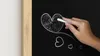 A hand drawing hearts on a chalkboard. Produktbild-Vorschau
