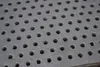 A close-up view of a perforated metal surface. Voir les images du produit