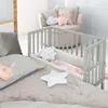 A nursery setting with a crib and bedding. Produktbild-Vorschau
