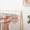 A person is hanging clothes on a clothing rack. Náhled obrázku produktu