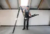 A man is holding a folded ladder in an attic space. Náhľad obrázku produktu