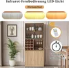 A modern display cabinet with wine storage and glass doors, set in a room with a plant and framed artwork. The image also includes marketing graphics highlighting LED lighting features. Náhled obrázku produktu