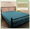 A teal fitted sheet is shown on a bed with a decorative metal headboard. Produktbild-Vorschau