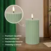 A green LED candle with a flame is shown on a wooden surface, with a green curtain in the background. A close-up inset shows the top of the candle and its flame. Podgląd zdjęcia produktu