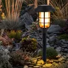 A solar-powered garden light illuminates a rocky garden bed at dusk. Produktbild-Vorschau