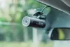 A dash cam is mounted on a car's windshield, with a rearview mirror visible. Voir les images du produit