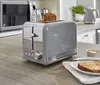 A kitchen counter with a toaster and a slice of toast. Produktbild-Vorschau