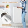 A person is holding a white laundry hamper next to a washing machine. Podgląd zdjęcia produktu