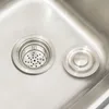 A close-up view of a stainless steel sink drain with a strainer and a separate drain cover. Náhled obrázku produktu