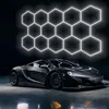 A black sports car is parked in front of a wall with a glowing hexagonal light pattern. Náhled obrázku produktu