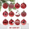 A collection of red glass Christmas ornaments hanging from a pine branch, with a snowy ground and text overlay at the bottom. Produktbild-Vorschau