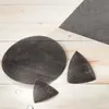 Several pieces of sandpaper are laid out on a light-colored wooden surface. Produktbild-Vorschau
