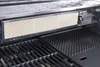 Close-up view of a gas grill's internal components, including the burner cover and grates. Podgląd zdjęcia produktu