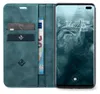 A teal flip-case wallet for a smartphone is shown open, with the phone displaying its lock screen. The wallet section contains credit cards and a banknote. Produktbild-Vorschau