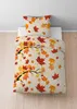 A duvet cover and pillow set with an autumn leaf pattern is displayed on a bed. Produktbild-Vorschau