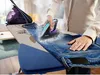 A person ironing jeans on an ironing board with a steam iron. Anteprima dell’immagine prodotto